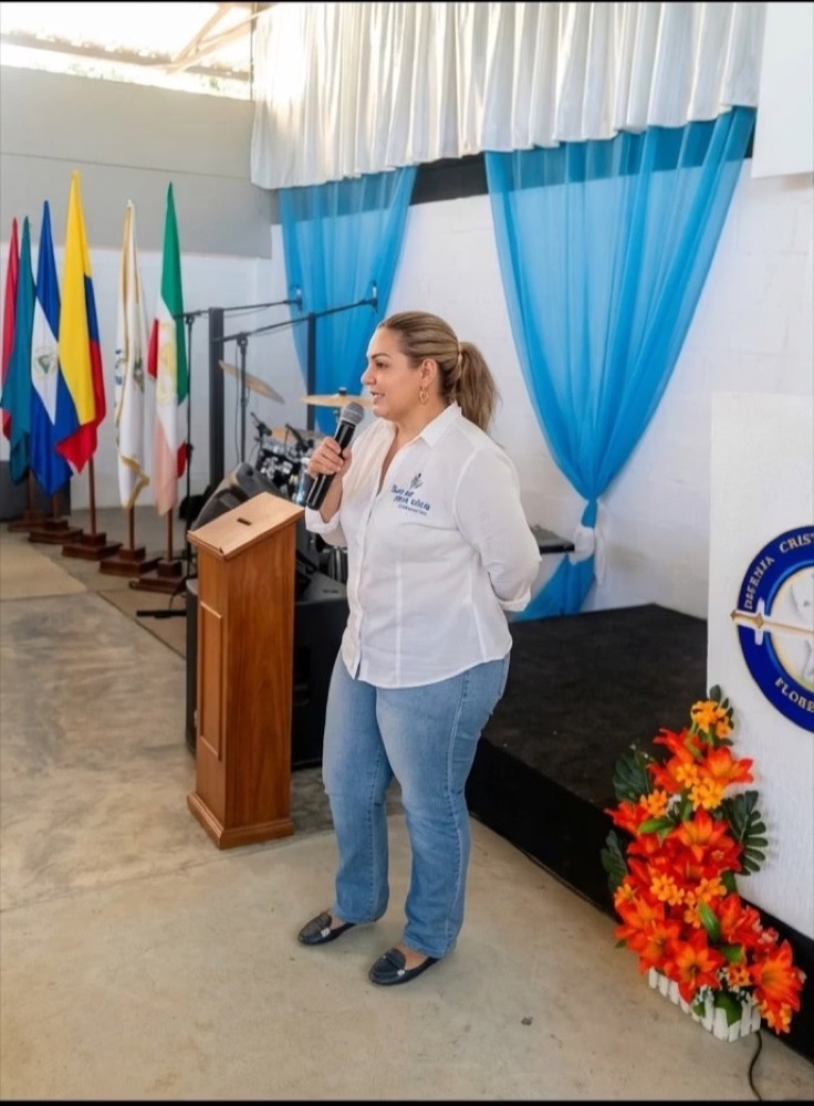 Mónica Botero Giraldo dirigiéndose al público con un micrófono durante una jornada de prevención
